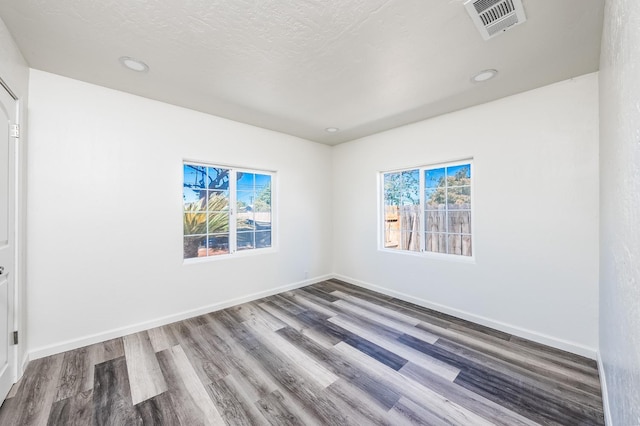 unfurnished room featuring a textured ceiling and wood-type flooring