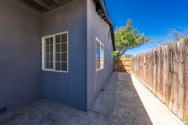 1845 N 10th Ave, Hanford, CA 93230 - view of side of home featuring stucco siding and a patio