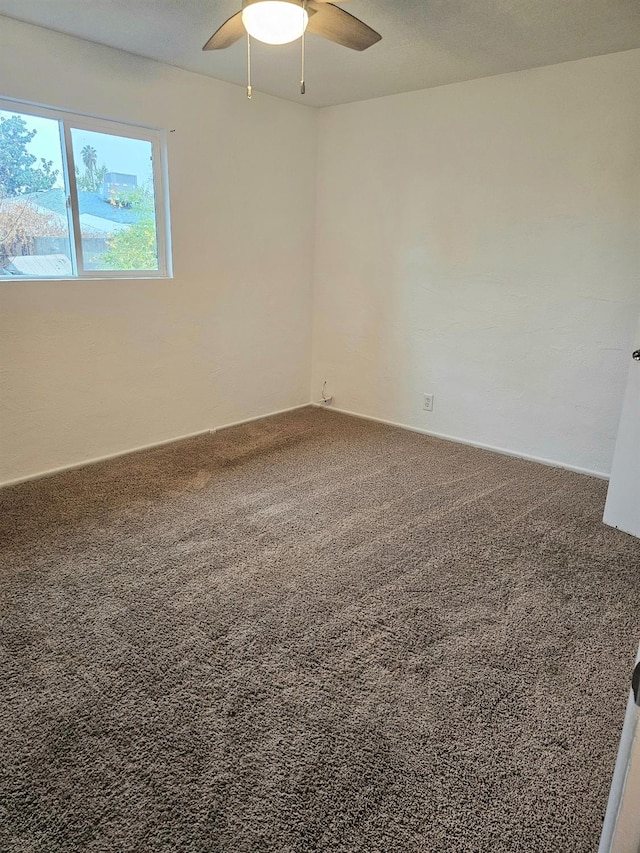 carpeted spare room featuring ceiling fan