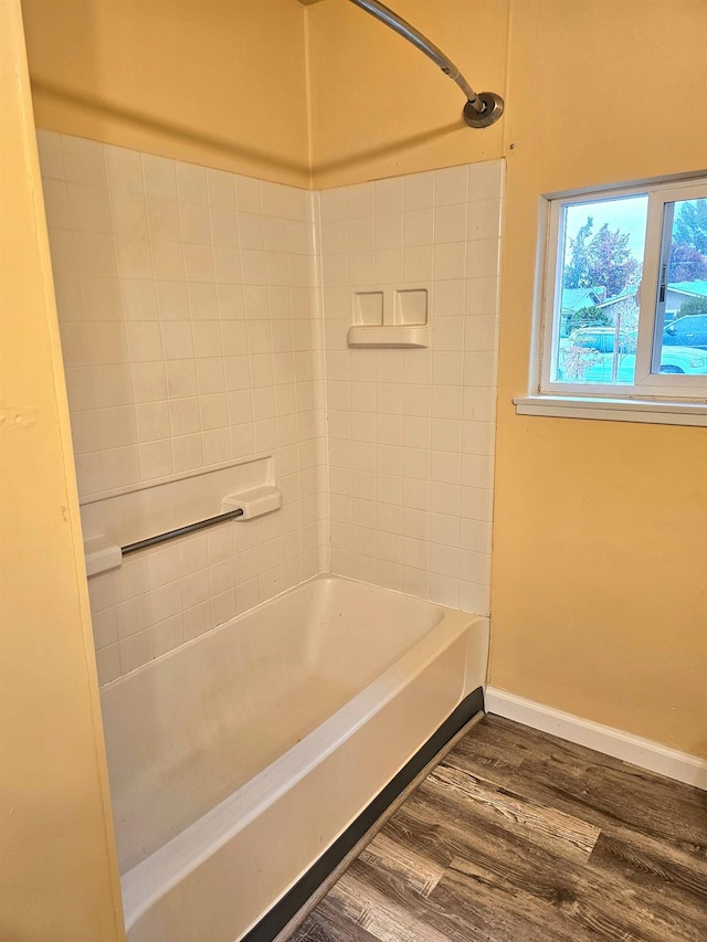 bathroom with hardwood / wood-style floors and tiled shower / bath