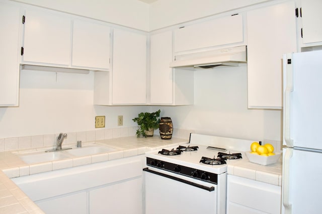 kitchen featuring tile counters, white appliances, and white cabinetry