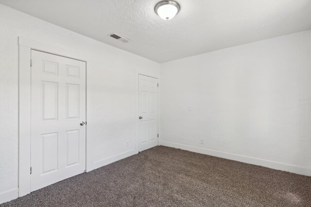 carpeted spare room featuring a textured ceiling