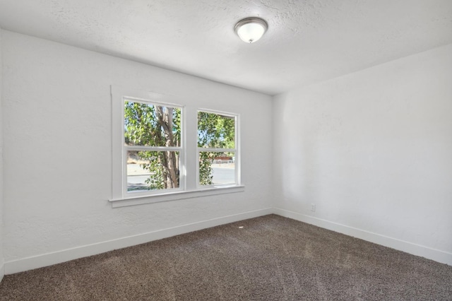 carpeted empty room featuring a textured ceiling