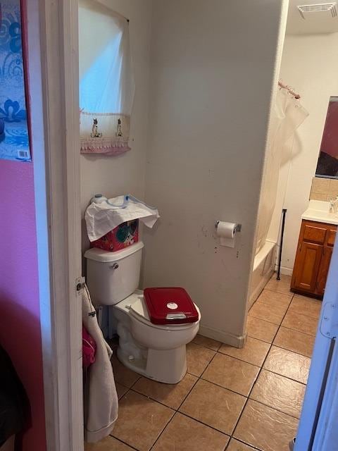 full bathroom featuring shower / tub combo with curtain, toilet, vanity, and tile patterned floors