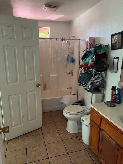 full bathroom featuring tile patterned flooring, shower / tub combo with curtain, toilet, and vanity