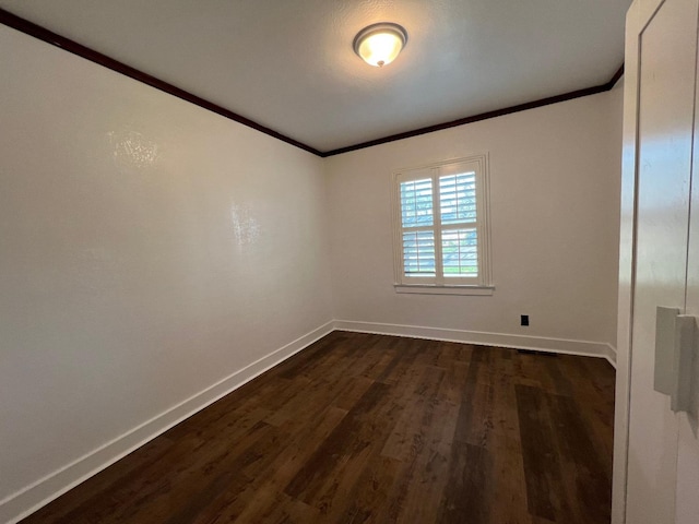 spare room featuring dark hardwood / wood-style flooring and crown molding