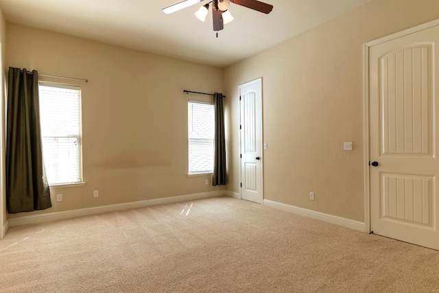 carpeted spare room featuring ceiling fan