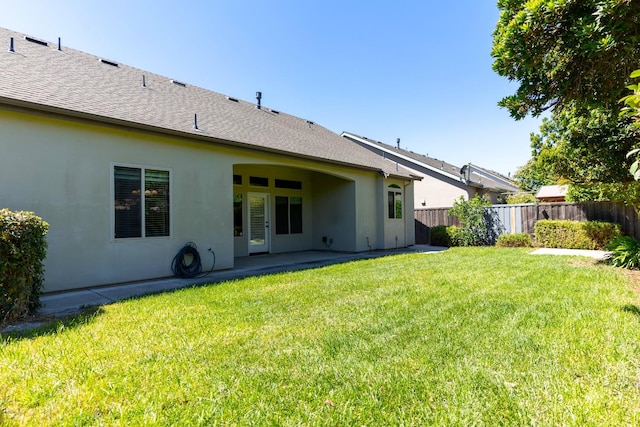 back of house with a patio area and a yard