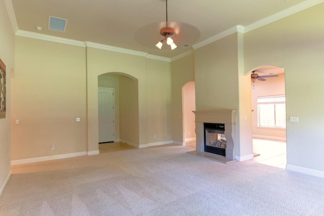 unfurnished living room featuring ceiling fan, ornamental molding, a multi sided fireplace, and light carpet