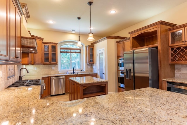 kitchen with appliances with stainless steel finishes, hanging light fixtures, decorative backsplash, and light stone countertops