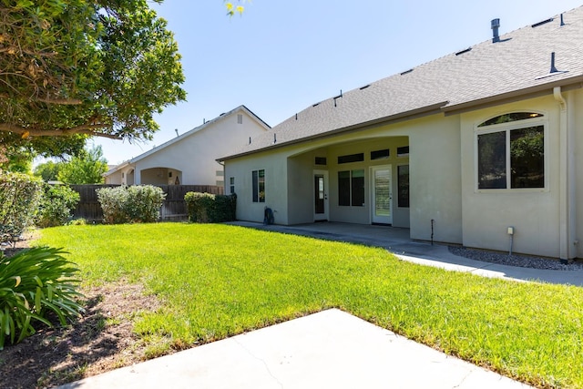 rear view of property with a patio and a lawn