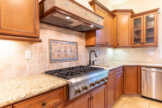 kitchen with custom range hood, tasteful backsplash, appliances with stainless steel finishes, light tile patterned floors, and sink