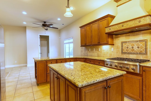 kitchen with ceiling fan, backsplash, a center island, and premium range hood