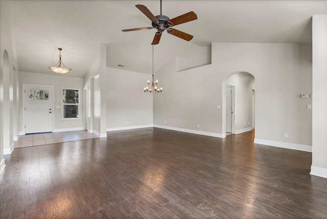 unfurnished living room featuring hardwood / wood-style flooring, high vaulted ceiling, and ceiling fan with notable chandelier