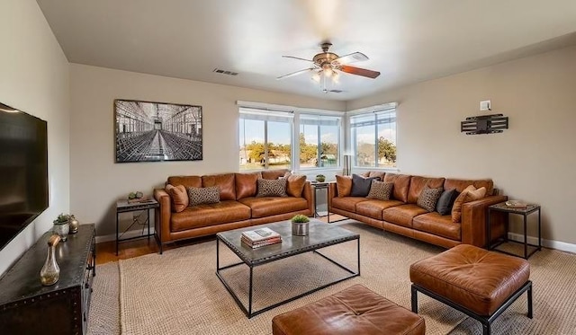 living area featuring visible vents, ceiling fan, and baseboards