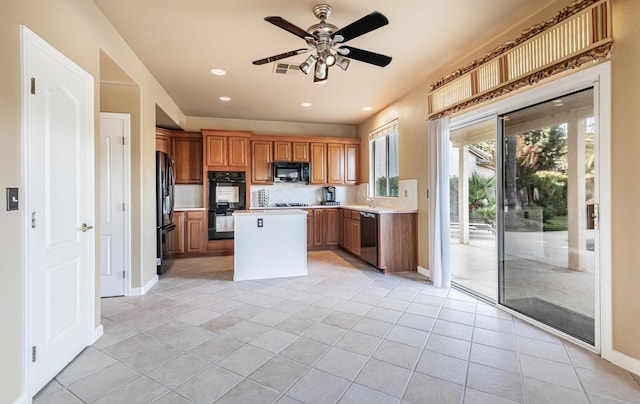 kitchen with light tile patterned floors, brown cabinetry, a center island, light countertops, and black appliances