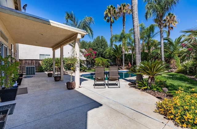 view of patio featuring fence, an outdoor pool, and central AC