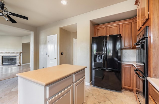 kitchen with decorative backsplash, light countertops, black appliances, and light tile patterned flooring