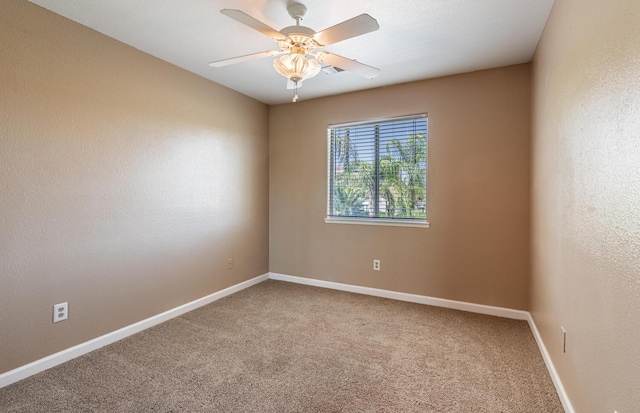 spare room with carpet floors, ceiling fan, baseboards, and a textured wall