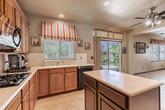 kitchen featuring decorative backsplash, a ceiling fan, light countertops, black appliances, and a sink