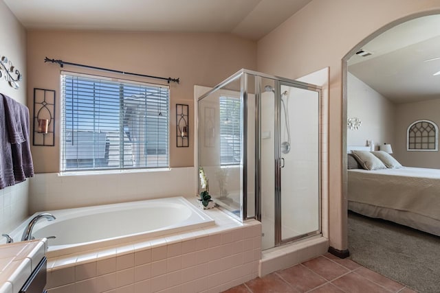 bathroom with a garden tub, tile patterned flooring, vaulted ceiling, and a stall shower