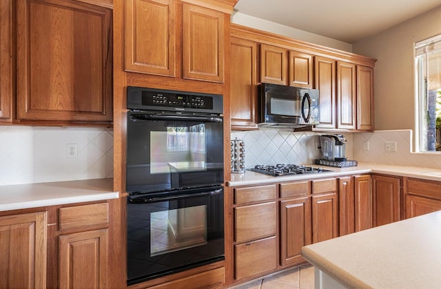 kitchen with dobule oven black, gas stovetop, light countertops, and brown cabinetry