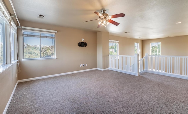 unfurnished room featuring carpet floors, visible vents, and baseboards