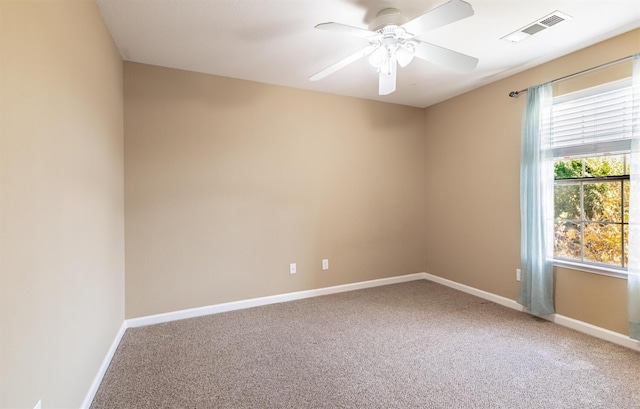 carpeted spare room with baseboards, visible vents, and a wealth of natural light