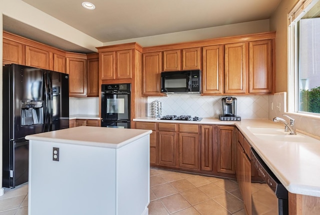 kitchen with light tile patterned floors, backsplash, light countertops, black appliances, and a sink