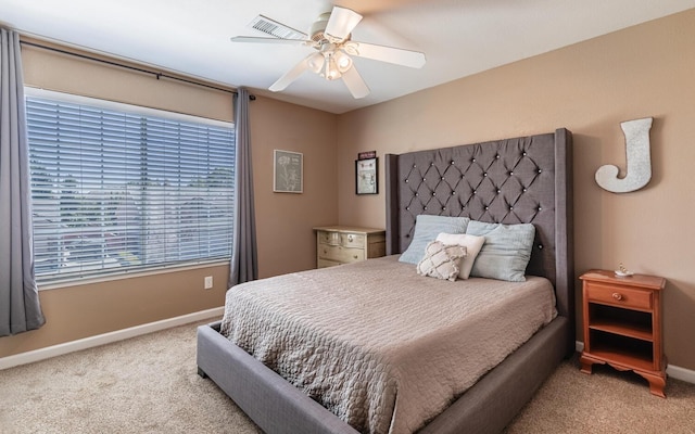 carpeted bedroom featuring a ceiling fan, visible vents, and baseboards