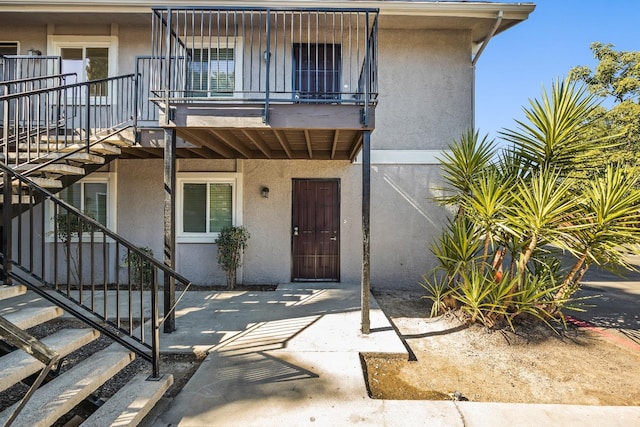 doorway to property with a balcony and a patio