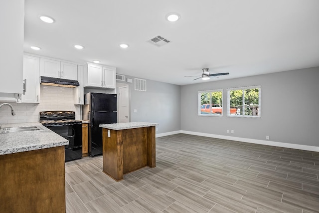 kitchen featuring backsplash, sink, black appliances, light stone countertops, and a kitchen island