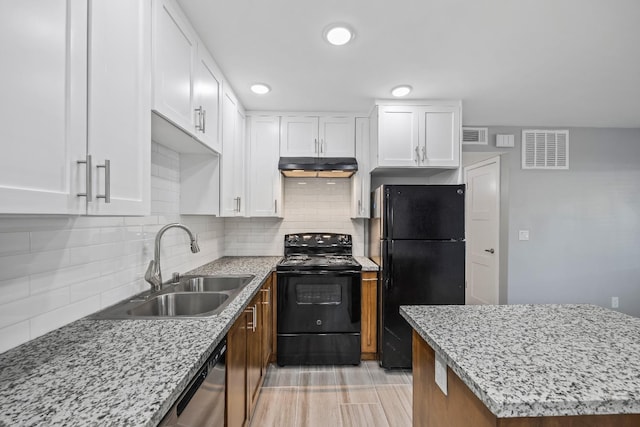 kitchen with light stone countertops, white cabinetry, black appliances, and tasteful backsplash