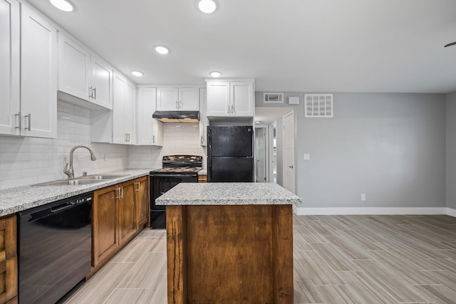 kitchen with sink, black appliances, backsplash, and light stone counters