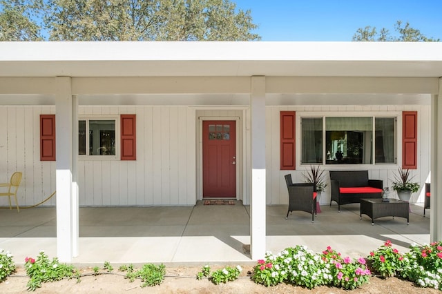 property entrance featuring a porch and an attached carport