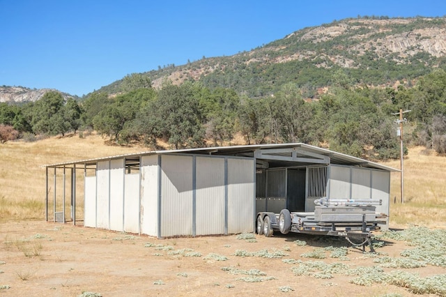 exterior space with a pole building, a mountain view, and an outbuilding