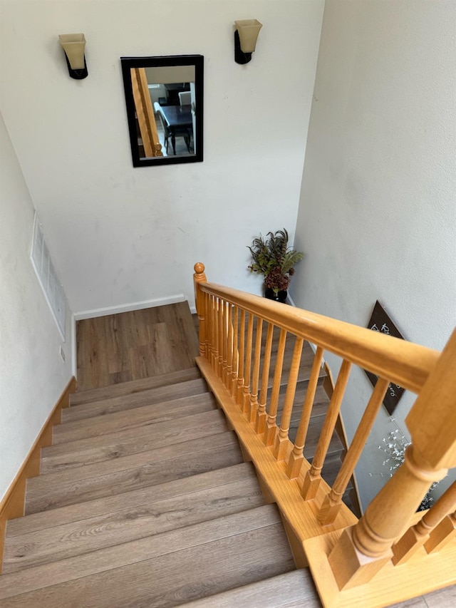 staircase with hardwood / wood-style flooring