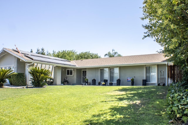 view of front of house with a garage, a front yard, and solar panels