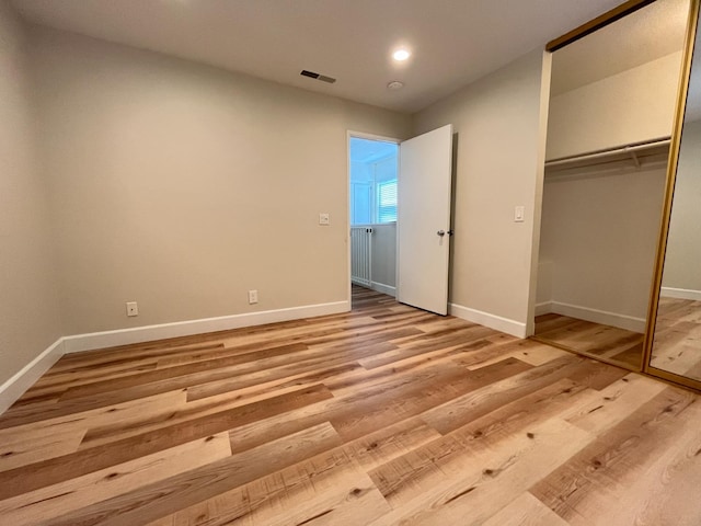 unfurnished bedroom featuring a closet and light hardwood / wood-style floors