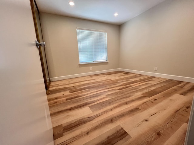 spare room featuring light wood-style flooring, baseboards, and recessed lighting