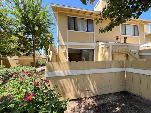 back of house with fence and stucco siding