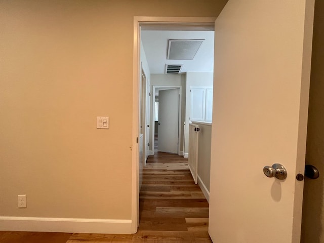 corridor featuring light wood-type flooring, baseboards, and visible vents