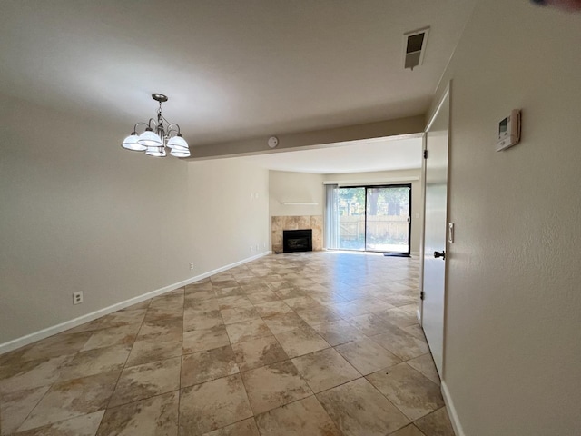 unfurnished living room with a chandelier, a fireplace, and baseboards