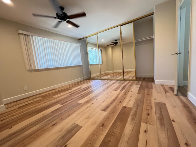 unfurnished bedroom with light wood-type flooring, ceiling fan, and a closet