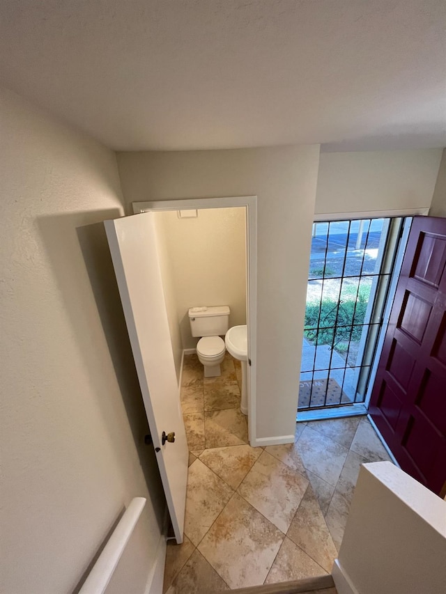 bathroom with toilet and baseboards