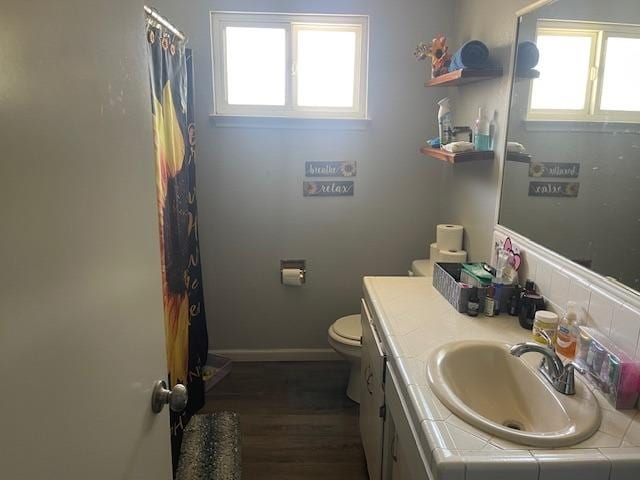 bathroom with hardwood / wood-style floors, toilet, and vanity