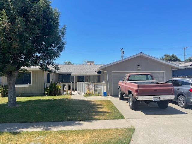 single story home with a garage and a front lawn