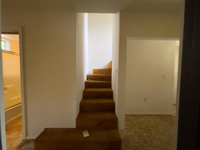 staircase featuring tile patterned flooring