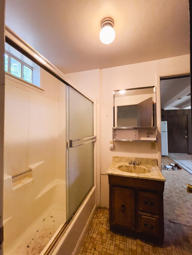 bathroom featuring enclosed tub / shower combo and vanity