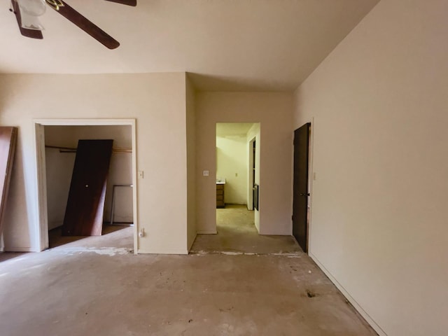 unfurnished bedroom with ceiling fan, concrete flooring, and a closet